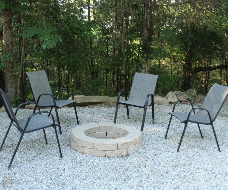 chairs and fire ring outside cabin at Great Escapes RV Resorts Branson