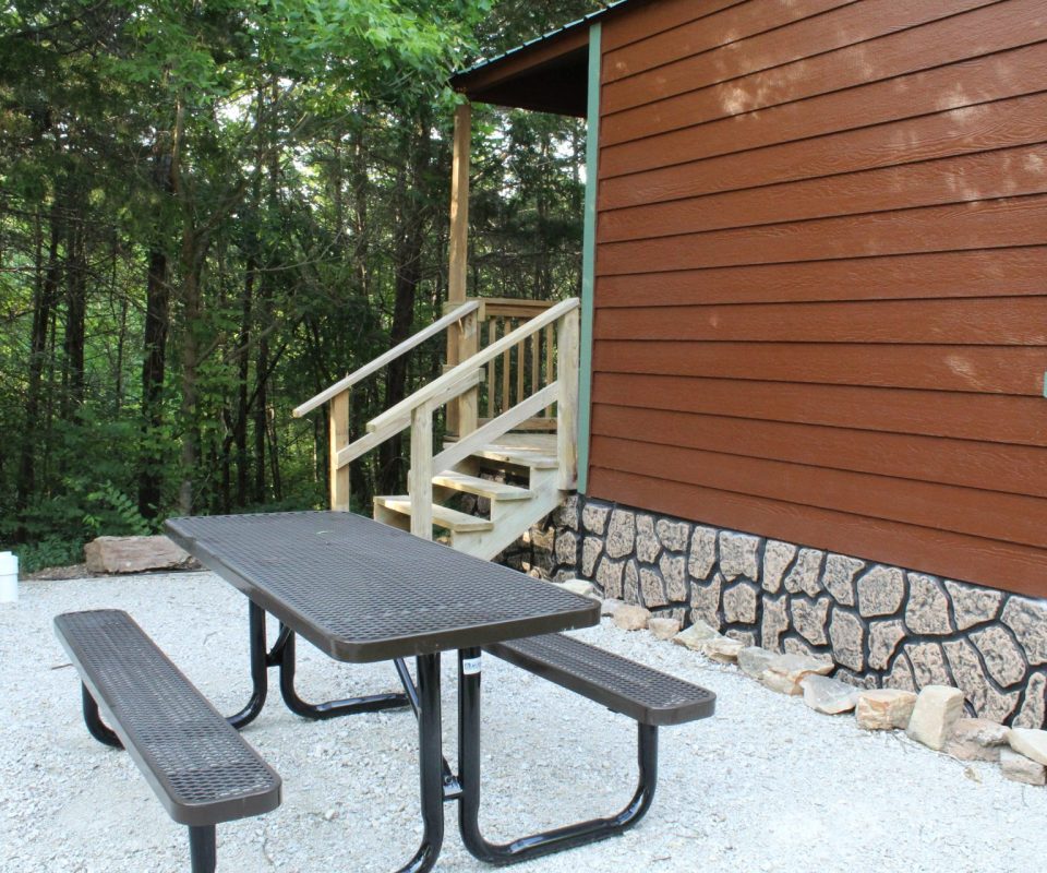 exterior view of cabin with picnic table at Great Escapes RV Resorts Branson