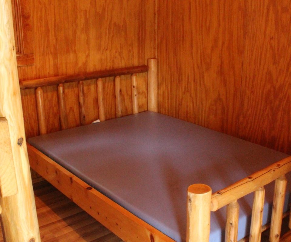 full-size bed in cabin at Great Escapes RV Resorts Branson