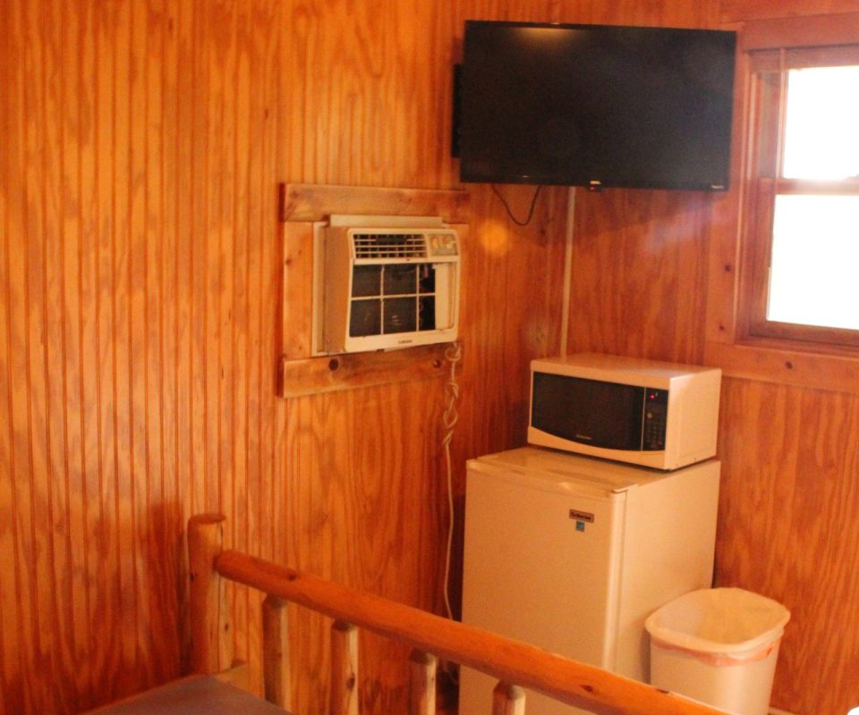 TV and microwave on top of mini-fridge in cabin at Great Escapes RV Resorts Branson