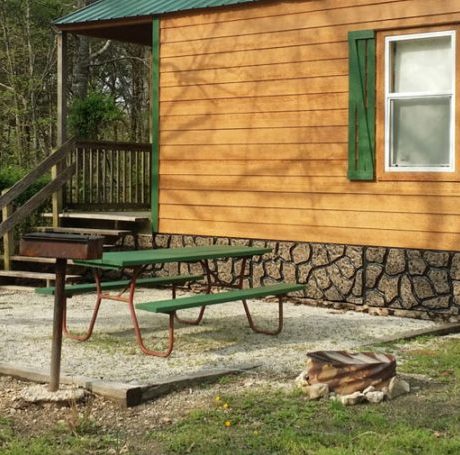 cabin exterior with picnic table and fire pit