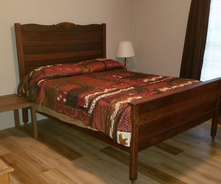 ozark house bedroom with bed and table at Great Escapes RV Resorts Branson