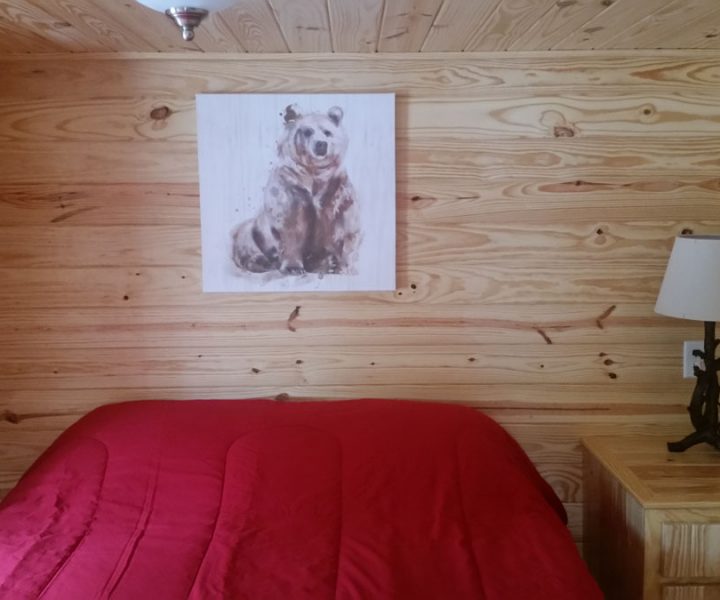 white river cabin interior bedroom with bed and artwork