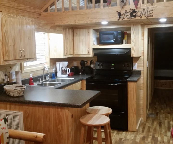 white river cabin interior kitchen with sink, oven, stove, and seating