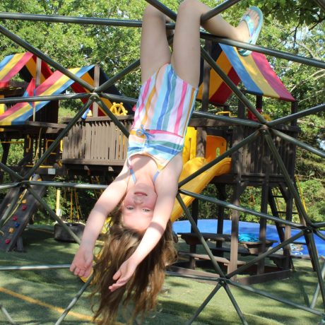 girl hanging from jungle gym at Great Escapes RV Resorts Branson