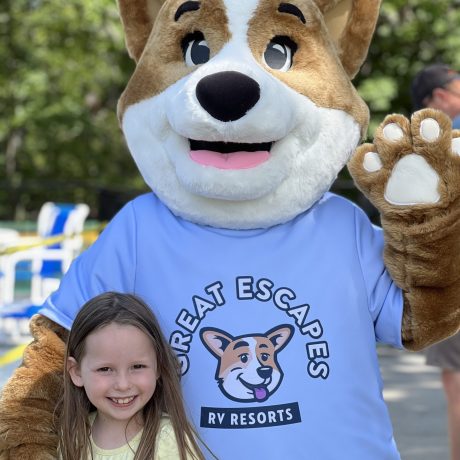 smiling Biscuit the camp mascot and girl at Great Escapes RV Resorts Branson
